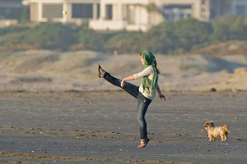 800px-Girl_kicking_a_ball_playing_on_the_sand_beach_in_late_light.jpg